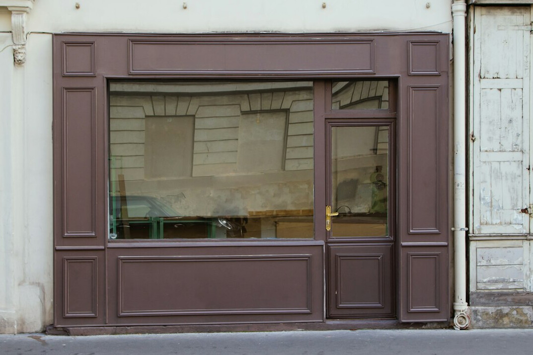 Vitrine de magasin avec passants dans une rue belge